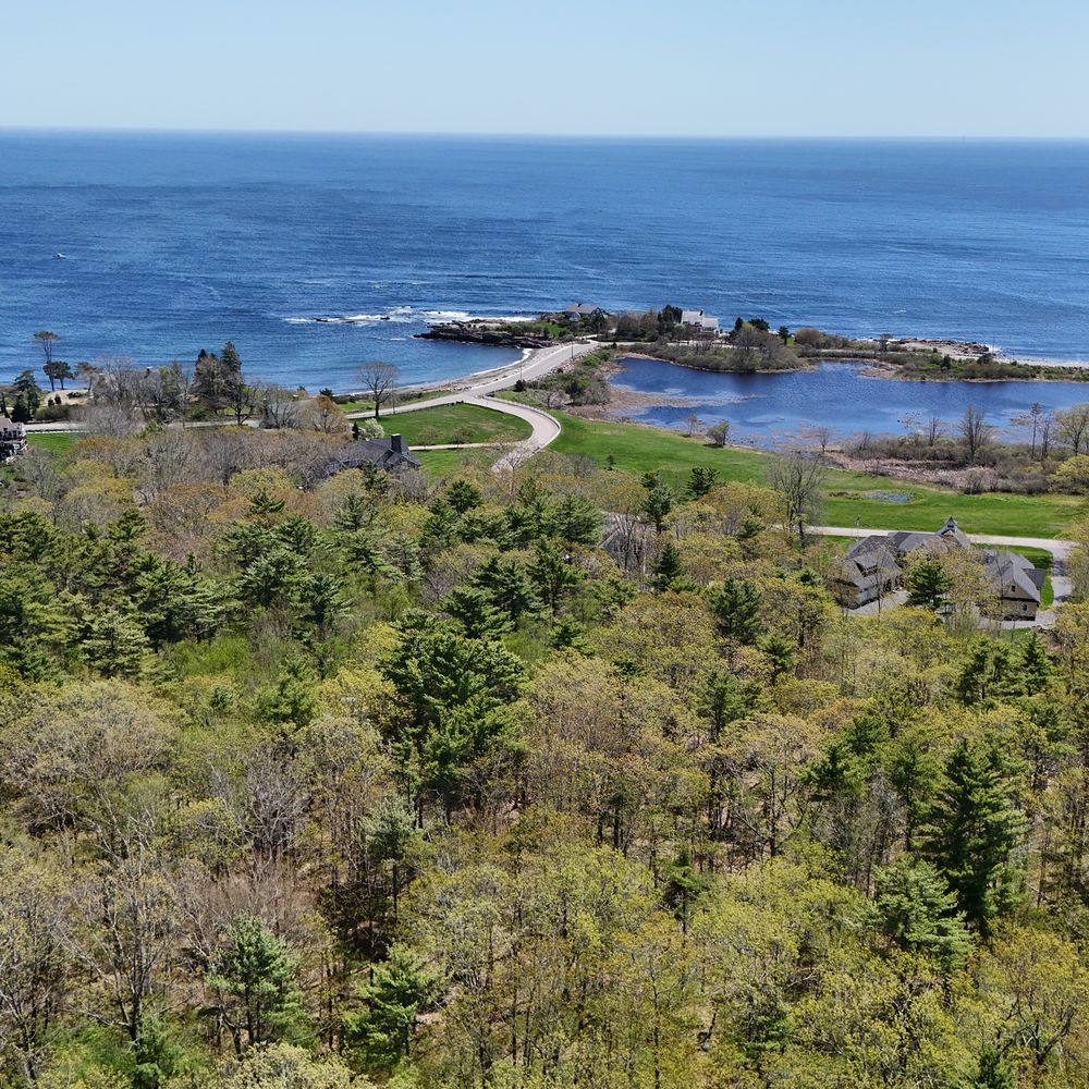 Aerial view of the southern Maine coast at York, with the tidal inlet, shore road and wooded hillside.